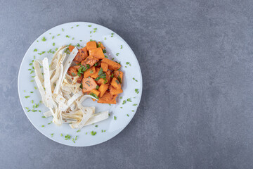 Tasty sliced lavash and baked carrot in plate , on the marble background