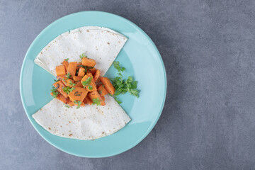 Lavash and baked carrot in plate , on the marble background