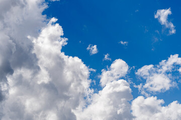 Large white clouds against a blue sky. Huge clouds like cotton wool in the sky.