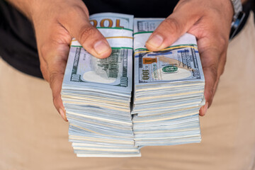 Bundles of US dollars in the hands of businessman. Selective focus