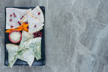 Slice pumpkin, lavash, gutab and a bowl of mayonnaise on the board, on the marble background