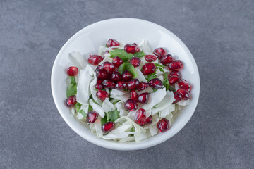 Pomegranate arils and grated vegetable, on the marble background