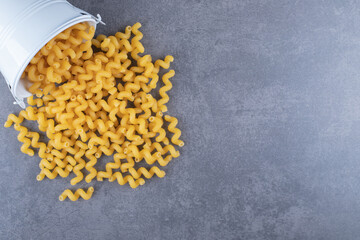 Raw elbow macaroni out of metal bucket