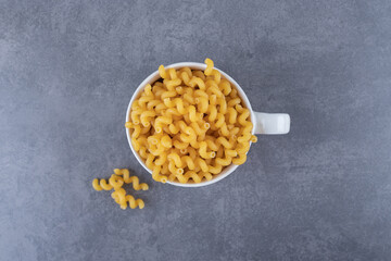 Obraz na płótnie Canvas Raw organic macaroni in ceramic cup