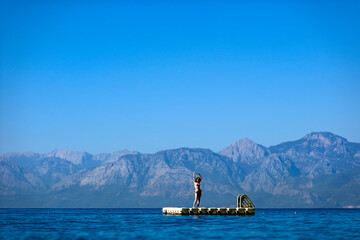 woman dancing on the pontoon at the sea 