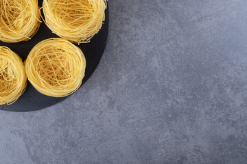 Raw egg noodles on black board