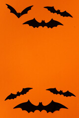 black bats above and below on an orange background leaving a space in the middle