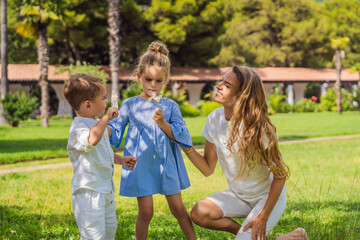 Naklejka premium Happy family outdoors on the grass in a park, smiling faces, having fun Portrait of a disgruntled girl sitting at a cafe table