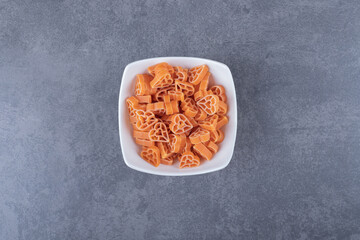 Pile of heart-shaped pasta in white bowl