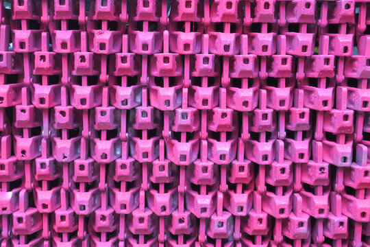 collection of pink painted parts of a scaffoling construction