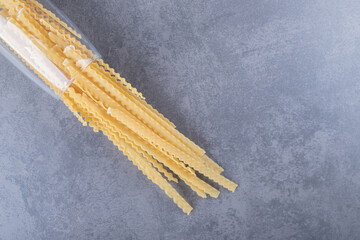 Pile of various-shaped dry pasta in glass