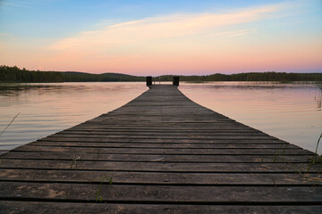 Fototapeta na wymiar Wooden jetty reaching into a swedish lake at blue hour. Nature from Scandinavia