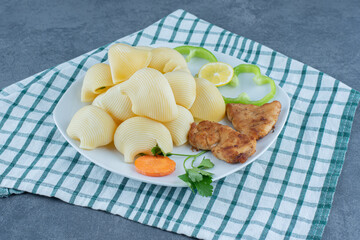 Chicken nuggets and boiled pasta on white plate