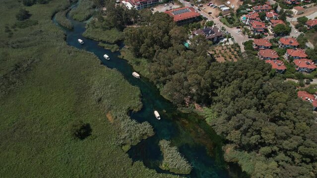 Excursion boats cruising on the Akyaka Azmak river. 4K footage with aerial drone