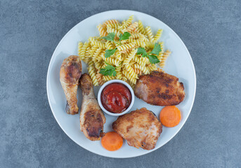 Fried chicken parts and fusilli on white plate