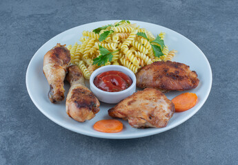 Fried chicken parts and fusilli on white plate