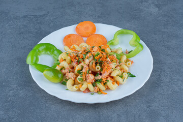 Tasty pasta with chopped vegetables on white plate