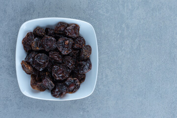 Dry cherry in the bowl, on the marble background