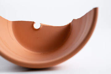 Broken terracotta pot close up on isolated white background. Manufactured defect. Shipment risk.