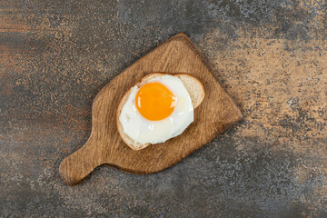 Toast bread with egg on wooden board