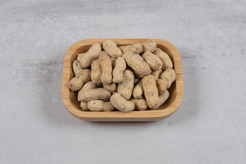 Tasty raw peanuts on wooden plate