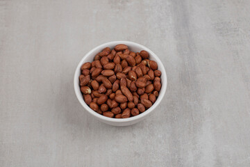 Heap of fresh peanuts in white bowl