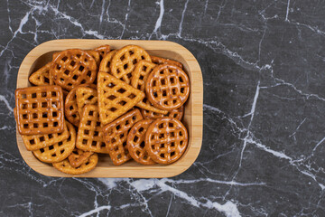 Delicious salty crackers on wooden plate
