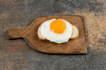 Toast bread with egg on wooden board