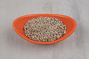 Pile of sunflower seeds in orange bowl