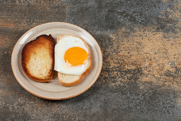 Toast and bread with egg on ceramic plate