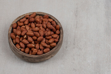 Heap of fresh peanuts in wooden bowl