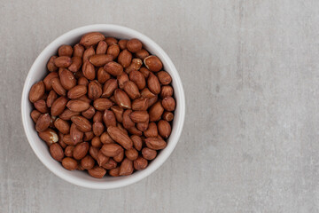 Heap of fresh peanuts in white bowl