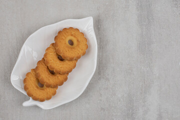 Tasty sweet biscuits on leaf shaped plate