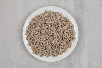 Pile of sunflower seeds on white plate