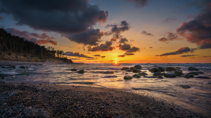 Obraz premium Wonderful orange sunset on the rocky coast of the sea