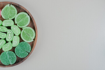 A wooden board full of green sugary marmalades