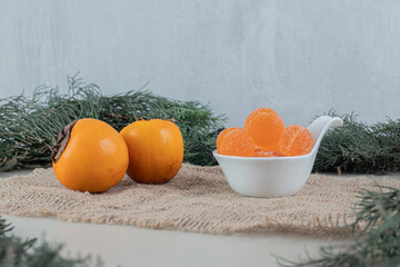 Pair of fresh persimmons with orange marmalades