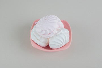 A pink plate with vanilla and pink zephyrs