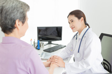 asian female doctor holding hand of old patient in mental health clinic, patient have a problem health in hospital, hand in hand, elderly healthcare promotion