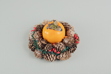 A Christmas wreath with a whole fresh persimmon