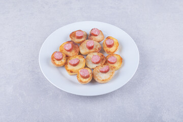 Smoked sausages with fried potato on white plate