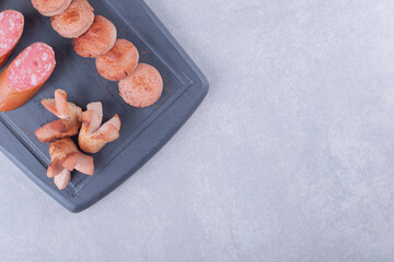 Fried and smoked tasty sausages on dark board