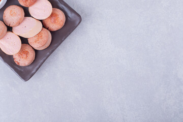 Fried and boiled tasty sausages on dark plate