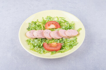 Sliced sausages and tomatoes on yellow plate
