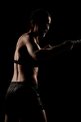Fototapeta na wymiar Strong fit girl with metal chain. Pulling and posing against black background..