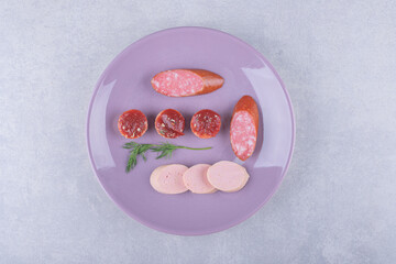 Boiled and smoked tasty sausages on purple plate