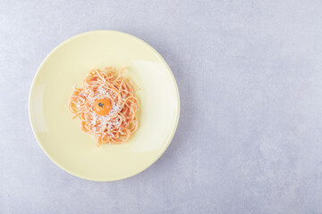 Tasty boiled spaghetti with tomatoes on yellow plate