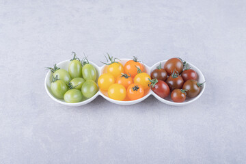 Colorful cherry tomatoes in white bowls
