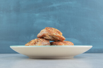 A blue plate with baked chicken meat