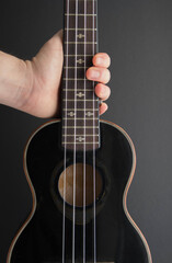 Obraz na płótnie Canvas Close up ukulele isolated on dark background. Copy text.
